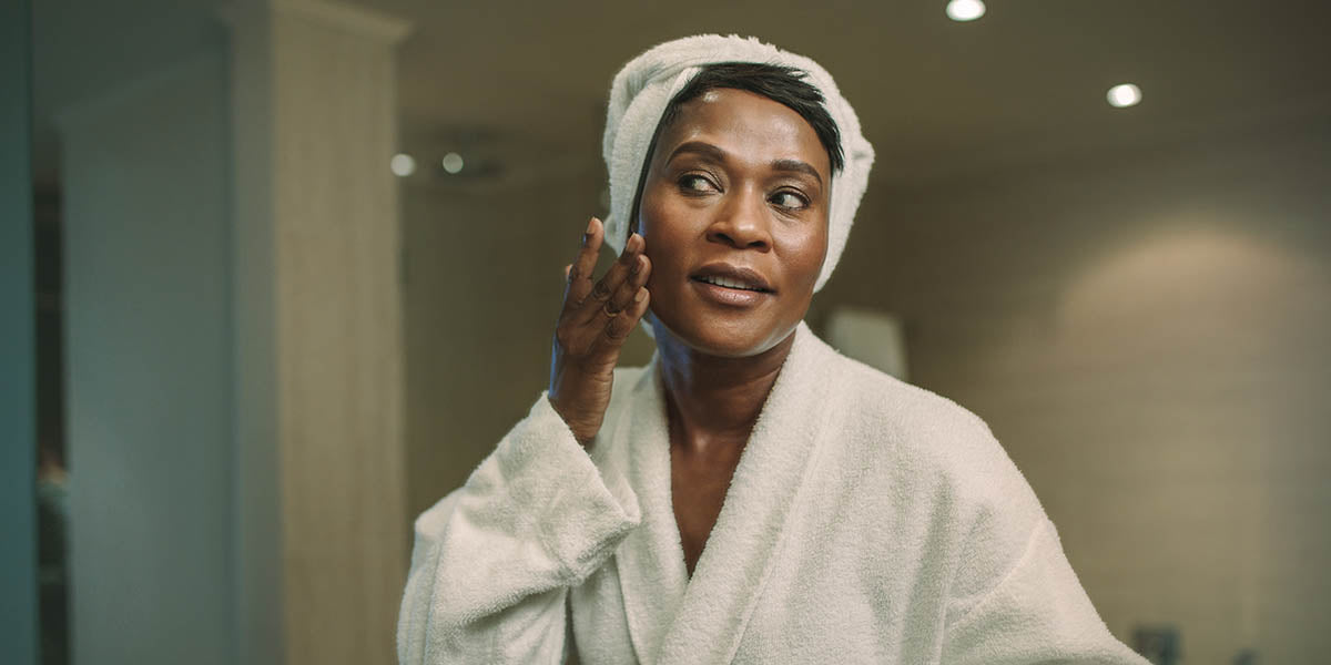 female putting on moisturizer on her face skin