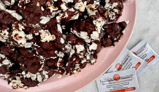 bowl of chocolate popcorn bark with packets of lypo-spheric vitamin c