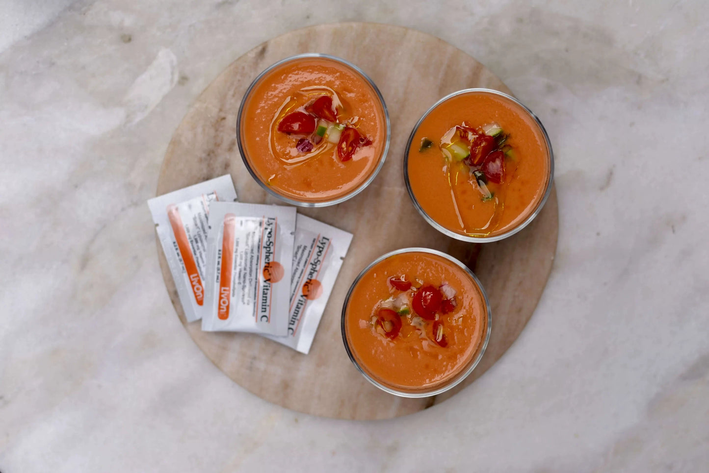 three bowls of gazpacho with packets of lypo-spheric vitamin c