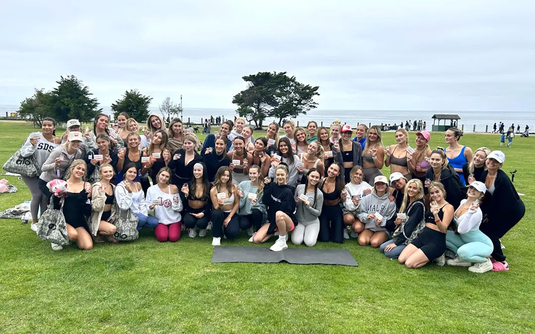 mental health advocate Britt Turpack and a group of college students pose outdoors at an event