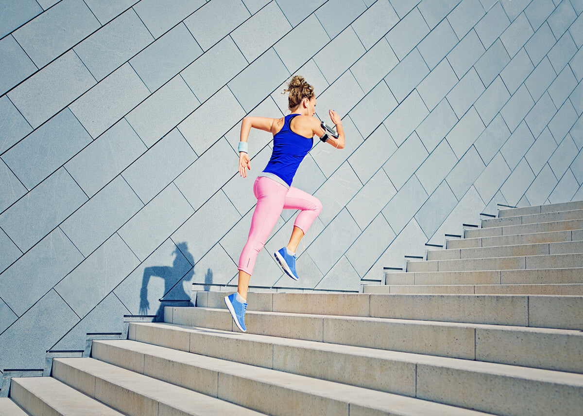 woman in working attire jogging up a flight of steps