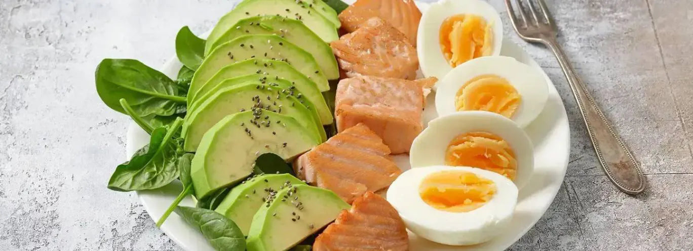plate of avocado, salmon, and eggs shows a meal to eat for mental health