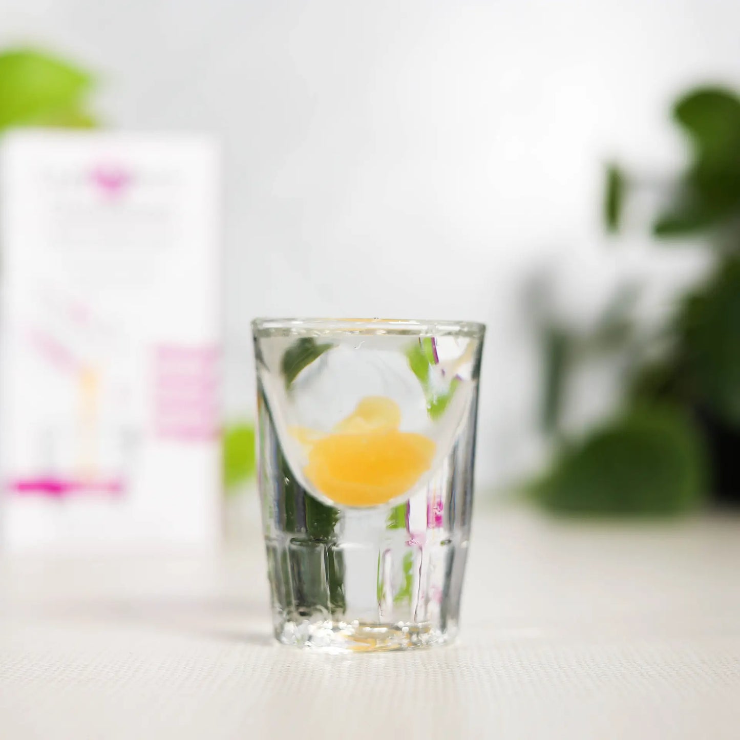 shot glass of lypo-spheric glutathione with carton in background