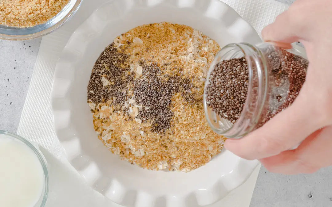 hand pouring chia seeds from a mason jar into a bowl of oatmeal