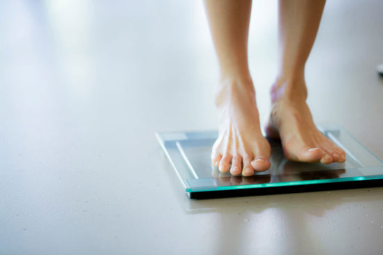 bare feet on bathroom scale illustrates acetyl l-carnitine for weight loss