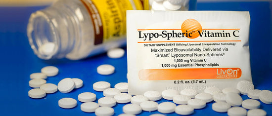 bottle of aspirin with scattered pills and packet of lypo-spheric vitamin c to replenish due to aspirin interactions with nutrients