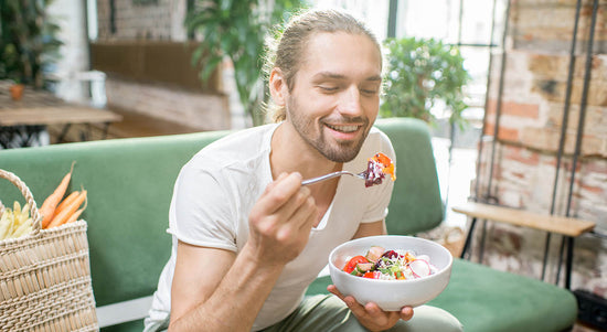 Vegetarian man eating salad indoors