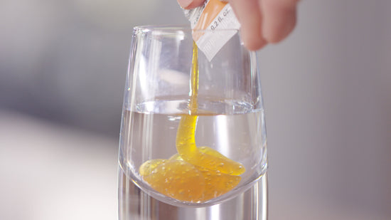 squeezing a packet of lypo-spheric vitamin c into a shot of water