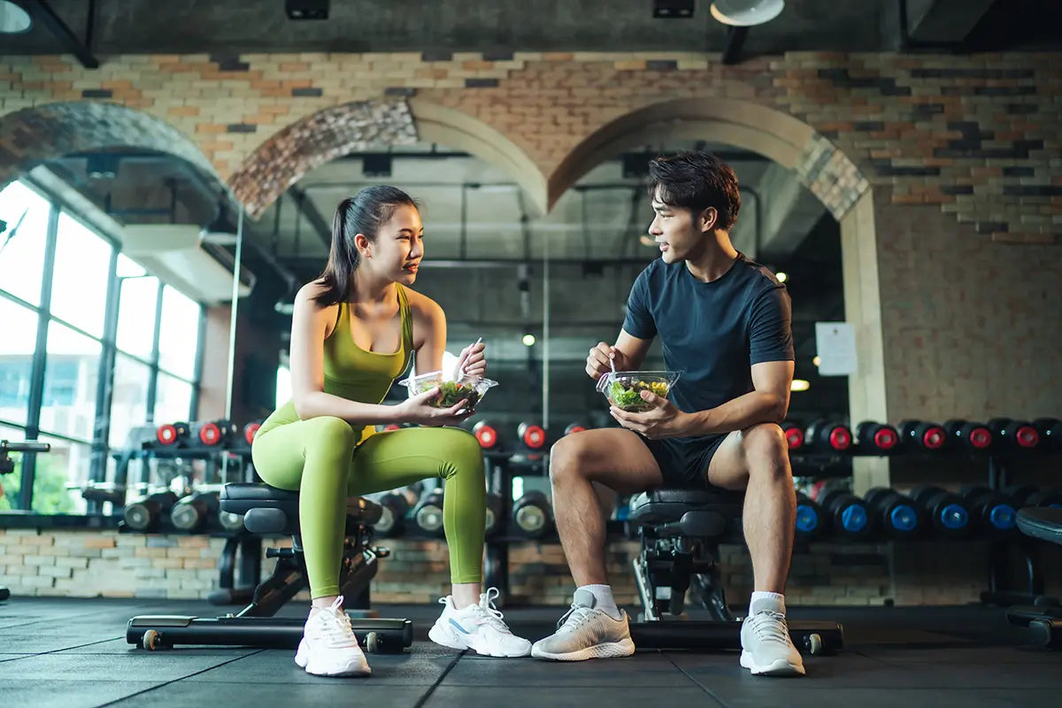 fit couple eating at a gym