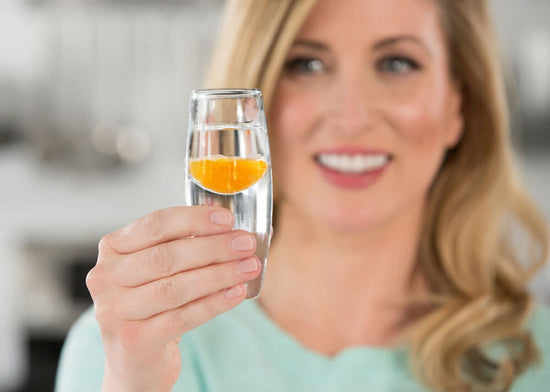 woman holding shot of lypo-spheric vitamin c