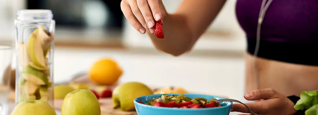 athletic person in kitchen making a fruit salad