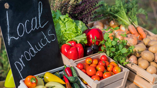 Counter with fresh vegetables and a sign of local produce that help maximize nutrients