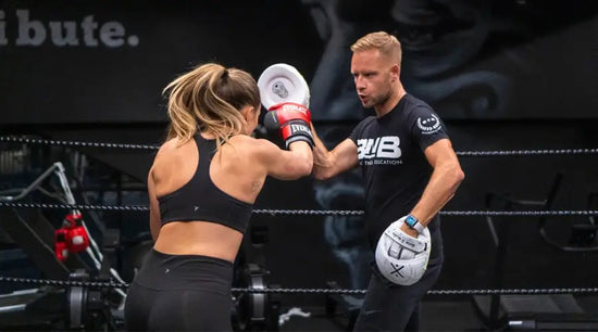 woman and man sparring in a ring