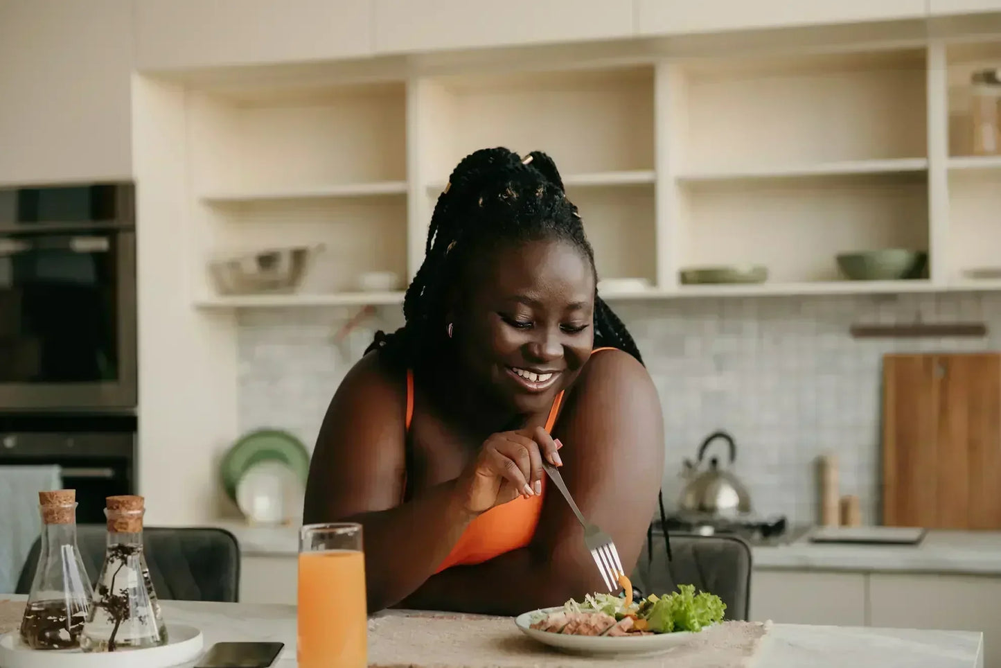 woman in a kitchen eating a healthy meal