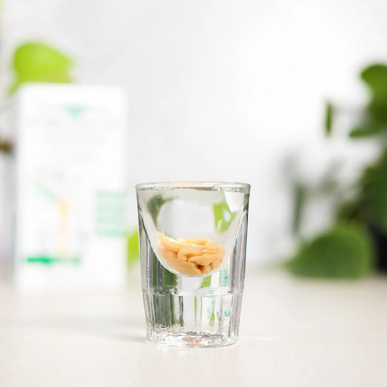 shot glass of lypo-spheric alpha lipoic acid with carton in background
