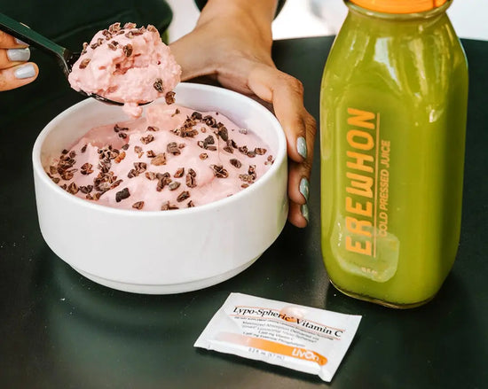 photo of woman's hands scooping Erewhon dessert with green juice bottle and packet of Lypo-Spheric Vitamin C