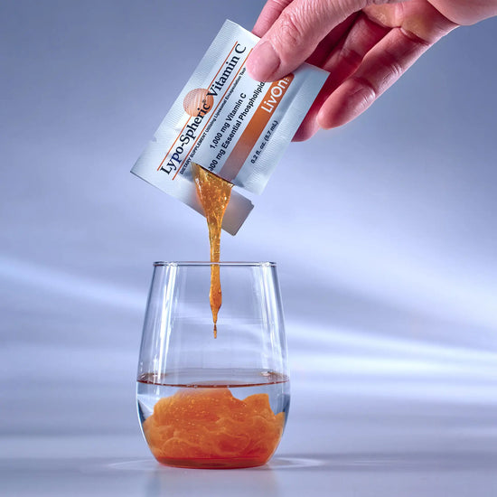 hand squeezing Lypo-Spheric® Vitamin C into a shot glass
