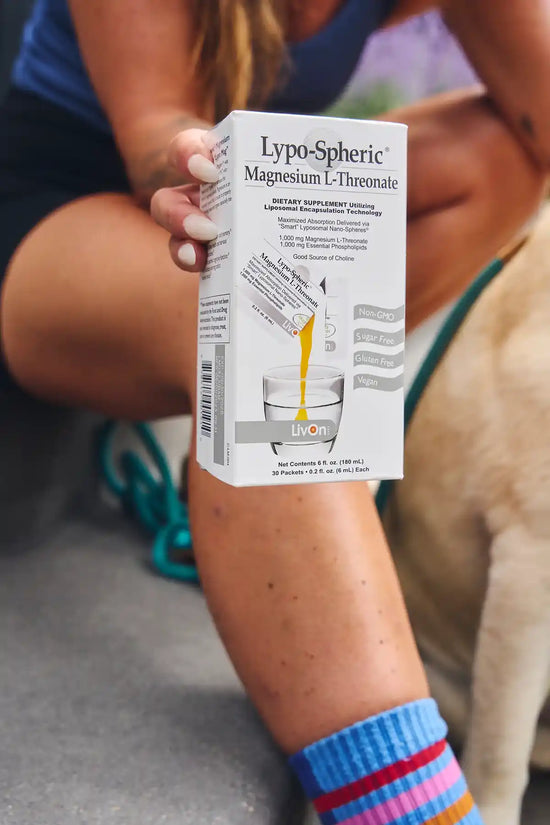 woman holding carton of lypo-spheric magnesium l-threonate