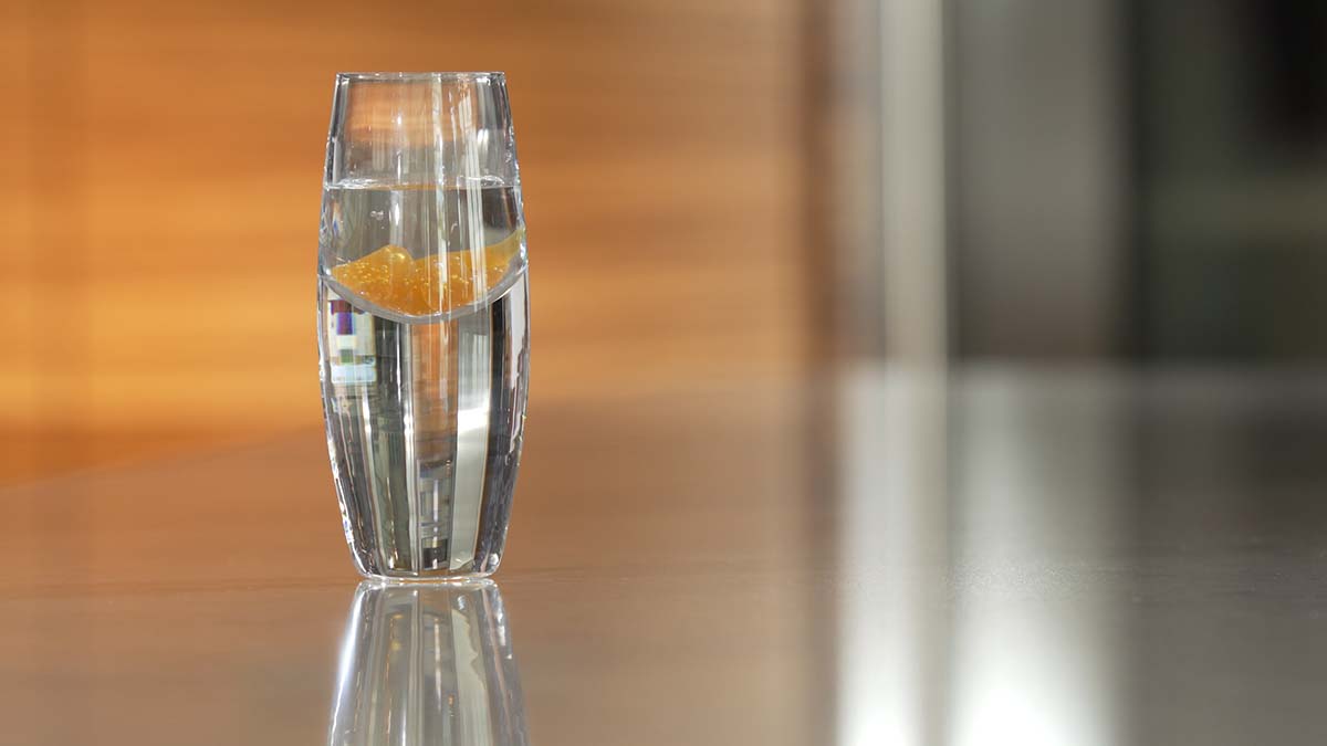 shot glass with LivOn Labs liposomal vitamin c blob in water showing how liposomal supplements do not dissolve in water